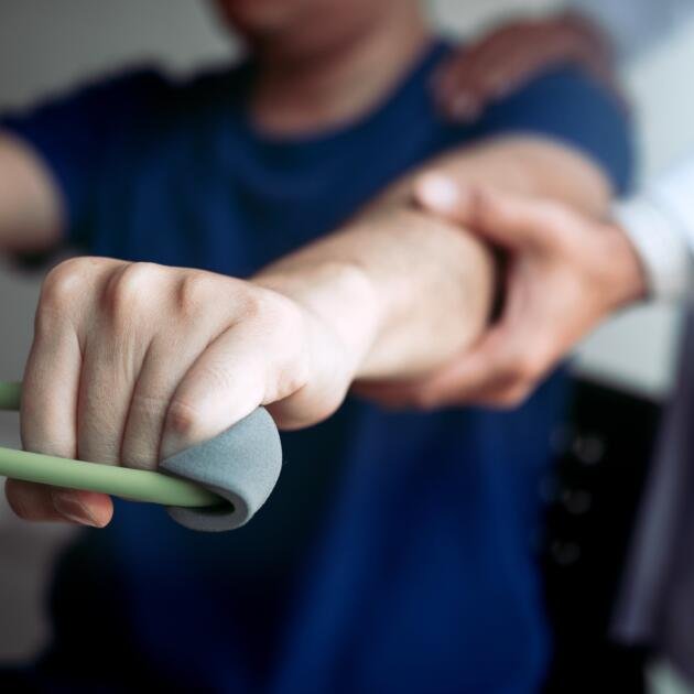 midsection-physical-therapist-assisting-patient-while-exercising-min