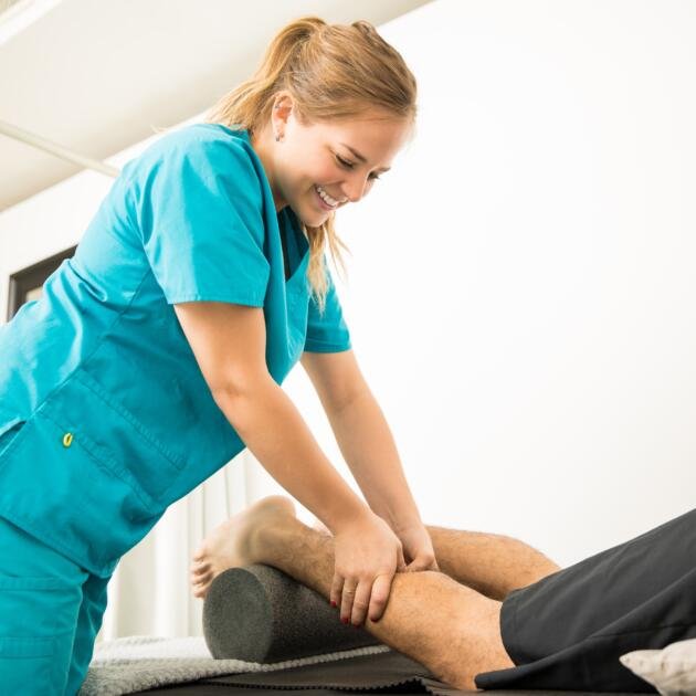 smiling-physiotherapy-specialist-giving-massage-patient-calf-pain-relief-hospital-min